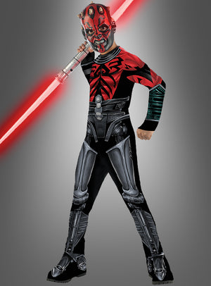 Ein Kind im Darth-Maul-Cyborg-Kostüm aus der Serie „The Clone Wars“, das ein rotes Doppelklingen-Lichtschwert in der Hand hält und vor einem schlichten grauen Hintergrund steht.