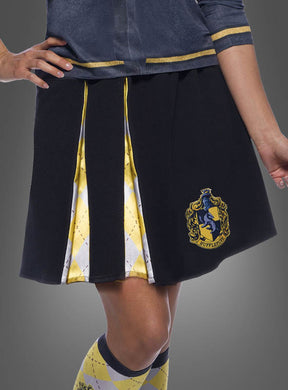 Eine Person trägt den „Hufflepuff Rock für Damen Harry Potter“, einen schwarzen Rock mit gelben und weißen Plisseefalten im Rautenmuster und einem Hufflepuff-Wappen, der den klassischen Stil der Hogwarts-Schuluniform widerspiegelt. Kombiniert mit passenden Socken und einem teilweise sichtbaren blauen Oberteil ist dies das ideale Harry-Potter-Kostüm für jeden Fan.