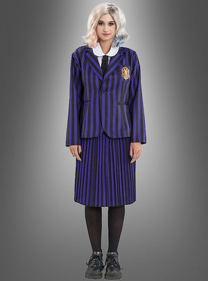 Diese Person trägt das Enid-Kostüm aus „Wednesday“ – bestehend aus einer schwarz-lila gestreiften Schuluniform mit Blazer und Rock, einem weißen Hemd, einer schwarzen Krawatte, schwarzen Strumpfhosen, schwarzen Schuhen und einer weißen Perücke – und verkörpert damit den ikonischen Look der Nevermore Academy, während sie vor einem grauen Hintergrund steht.
