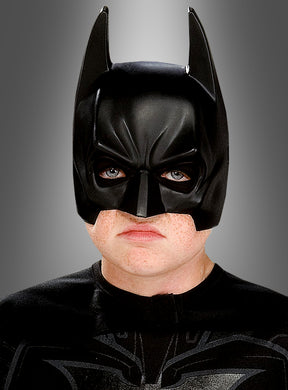 Eine Person, die die „Batman-Maske für Erwachsene“ und ein schwarzes Kostüm trägt, blickt vorwärts vor einem grauen Hintergrund mit Farbverlauf.