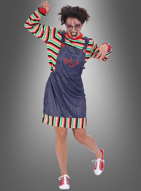 Eine Person, die das „Mörderpuppe“-Kleid für Damen trägt, kombiniert mit einem gestreiften Shirt, einem von einem Chucky-Kostüm inspirierten Jeansoverall, zerzausten Haaren, gruseligem Gesichts-Make-up und roten Schuhen, posiert mit einem erhobenen Arm vor einem grauen Hintergrund.