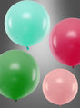 Vier runde Ballons in den Farben Blaugrün, Rot, Grün und Hellrosa – jeweils XXL „Runde Riesen“-Ballons (60–100 cm) – schweben vor einem grauen Hintergrund mit Farbverlauf. Ihre beeindruckende Größe und ihre leuchtenden Farben sorgen für einen auffälligen Anblick.