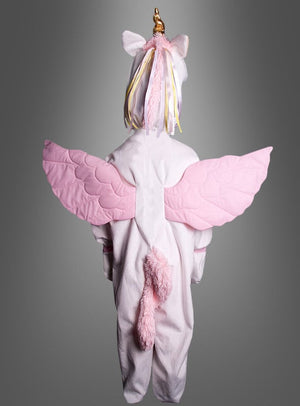 Ein Kind, das das „Zauberhaftes Plüsch-Einhorn-Kostüm Deluxe“ trägt – mit rosa Flügeln, einem Schwanz und einem goldenen Horn –, steht mit dem Rücken zu einem grauen Hintergrund – damit ist es die perfekte Wahl unter den Tierkostümen für Mädchen zu Fasching, Karneval oder Halloween.