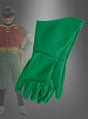 Im Vordergrund sind ein Paar grüne Robin-Kinderhandschuhe aus der Batman-Reihe zu sehen, während im Hintergrund ein Kind in einem Robin-Kostüm aus dem legendären Batman-Universum zu erkennen ist.