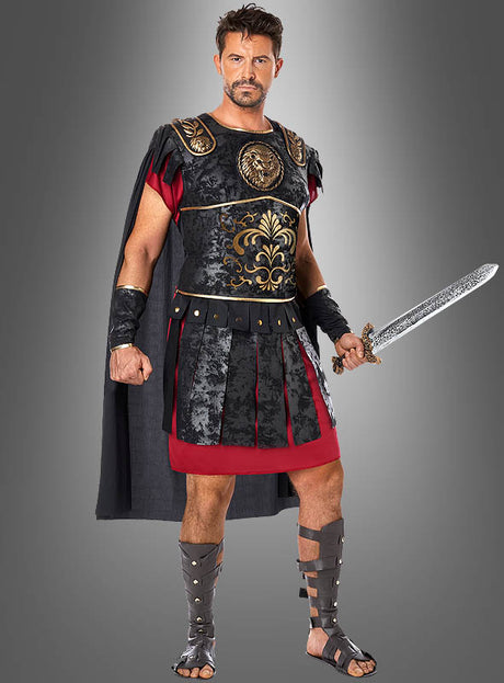 Vor einem grauen Hintergrund steht ein Mann, der das „Maximus Gladiator“-Kostüm im römischen Stil trägt – bestehend aus schwarzer Rüstung, einer roten Tunika, gepanzerten Sandalen und einem dunklen Umhang – und ein Schwert in der Hand hält.