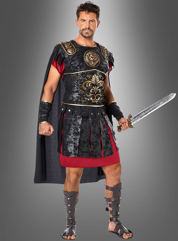 Vor einem grauen Hintergrund steht ein Mann, der das „Maximus Gladiator“-Kostüm im römischen Stil trägt – bestehend aus schwarzer Rüstung, einer roten Tunika, gepanzerten Sandalen und einem dunklen Umhang – und ein Schwert in der Hand hält.