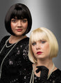 Zwei Frauen mit stilvollen kurzen Bob-Frisuren – die eine trägt die hochwertige Pagenschnitt-Bob-Perücke „Vera“ in glänzendem Schwarz, die andere einen schicken blonden Bob – posieren elegant in schwarzen Paillettenkleidern und mit Perlenketten vor einem grauen Hintergrund mit Farbverlauf.