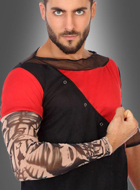 Ein Mann, der ein rot-schwarzes Shirt mit Netzkragen trägt, posiert vor einem grauen Farbverlaufshintergrund mit angewinkeltem Arm, der von einer „Eine Tattoo Fake Armstulpe“ mit aufwendigen Tattoo-Motiven bedeckt ist.