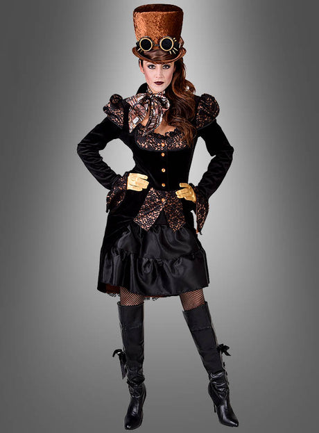 Eine Frau in einem Steampunk-Kostüm mit einem hohen braunen Zylinder, einer Schutzbrille, einem schwarzen Kleid mit goldenen Akzenten, goldenen Handschuhen und kniehohen schwarzen Stiefeln – ihr Look wird durch die auffällige Steampunk-Jacke „Lady Herriet“ im viktorianischen Stil abgerundet – posiert vor einem grauen Hintergrund mit Farbverlauf.