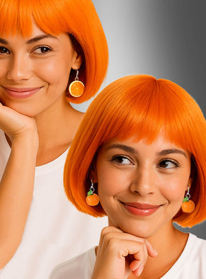 Eine Frau mit einer leuchtend orangefarbenen Bob-Perücke und orangefarbenem Schmuck, darunter auffällige Ohrringe in Form von Orangenscheiben oder ganzen Orangen, ist in einer geteilten Komposition vor grauem Hintergrund zu sehen.