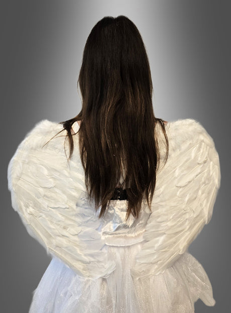 Eine Person mit langen braunen Haaren, gekleidet im „Sexy Engel Kostüm 3-tlg mit Tüll“ und mit gefiederten Engelsflügeln, ist von hinten vor einem grauen Hintergrund mit Farbverlauf zu sehen.