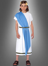 Ein Kind, gekleidet in die „Römer Toga für Kinder“ – mit weißer Tunika, blauer Schärpe, goldenem Gürtel und einem Lorbeerkranz als Kopfschmuck – steht vor einem grauen Hintergrund mit Farbverlauf und eignet sich somit ideal als römisches Kostüm für Mottopartys und Veranstaltungen.