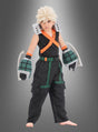 Ein Kind steht barfuß vor einem grauen Hintergrund und trägt das Katsuki-Bakugo-Kostüm für Kinder aus „My Hero Academia“ – mit einer stacheligen blonden Perücke, einem schwarzen Kostüm mit orangefarbenen Trägern, großen grauen Handschuhen und grünen Details – ideal für jeden jungen Fan, der einen authentischen Look sucht.