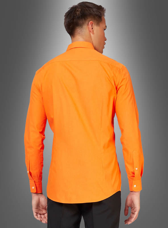 Ein Mann ist von hinten zu sehen: Er trägt ein orangefarbenes klassisches Herrenhemd mit figurbetontem Schnitt und eine schwarze Hose vor einem neutralen Hintergrund mit Farbverlauf.