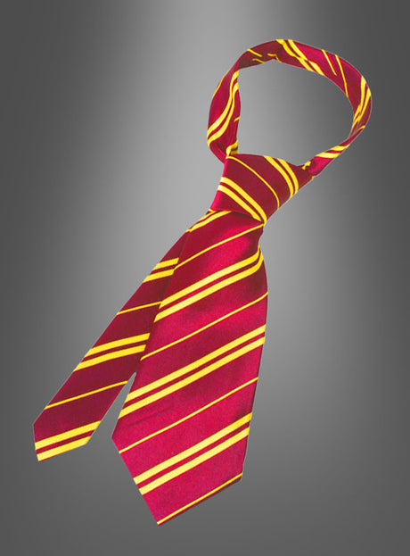Eine Harry-Potter-Krawatte von Gryffindor aus leuchtend rotem Stoff mit gelben diagonalen Streifen ist locker gebunden und vor einem grau verlaufenden Hintergrund abgebildet.