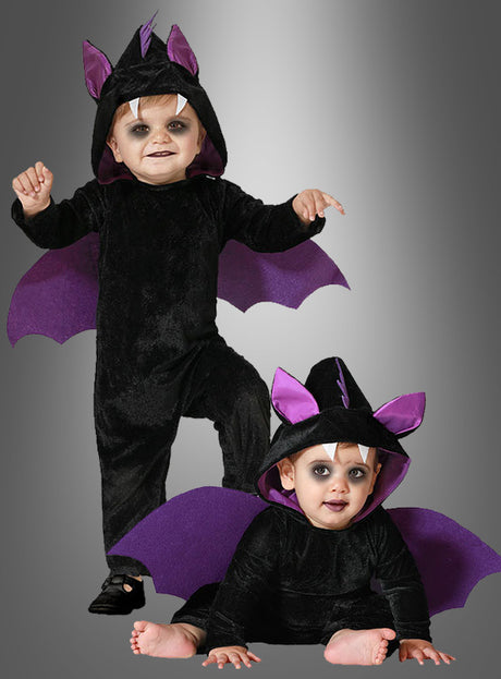 Zwei Kleinkinder tragen bezaubernde Fledermaus-Babykostüme in Schwarz und Lila, komplett mit Kapuzen, Ohren und Flügeln, während sie vor einem grauen Hintergrund mit Farbverlauf posieren – ideal für ein lustiges Halloween-Kostüm.