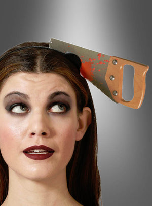 Eine Frau mit auffälligem Make-up trägt das „Horror-Haarreif Werkzeuge im Kopf“ – ein Stirnband mit einer künstlichen Säge, die mit roter Farbe bemalt ist und den Anschein erweckt, als würde sie durch ihren Kopf schneiden. Perfekt für ein Halloween- oder Horror-Kostüm.