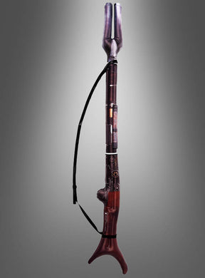 Ein Kontrafagott, ein großes Holzblasinstrument mit einem gebogenen Metallrohr und einem dunkelrotbraunen Korpus, steht aufrecht vor einem grauen Hintergrund mit Farbverlauf; seine dramatische Silhouette erinnert an den aufblasbaren Mandalorianer-Blaster aus „Star Wars“.