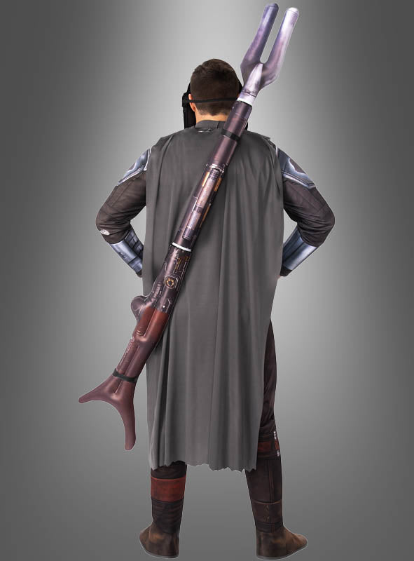 Eine Person in einem Mandalorianer-Kostüm steht mit dem Rücken zur Kamera, trägt einen grauen Umhang und hat den aufblasbaren STAR WARS Mandalorianer-Blaster auf dem Rücken, vor einem grauen Hintergrund mit Farbverlauf.