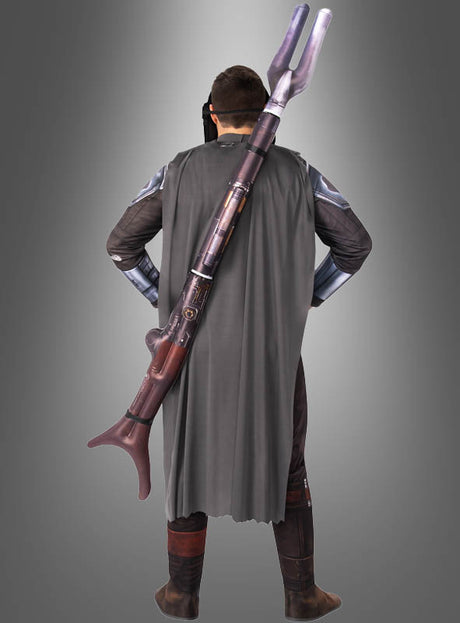 Eine Person in einem Mandalorianer-Kostüm steht mit dem Rücken zur Kamera, trägt einen grauen Umhang und hat den aufblasbaren STAR WARS Mandalorianer-Blaster auf dem Rücken, vor einem grauen Hintergrund mit Farbverlauf.