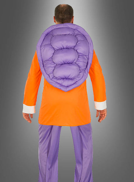 Eine Person, die mit dem Rücken zur Kamera steht und das „Dragon Ball Z“-Kostüm „Muten-Roshi“ trägt – ein orangefarbenes Outfit mit violetten Hosen und einem großen, gepolsterten, muschelartigen Accessoire auf dem Rücken –, steht vor einem neutralen Hintergrund.
