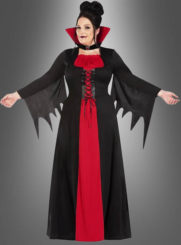 Eine Person trägt das „Vampir-Kostüm Damen Übergröße XXL“ – ein schwarz-rotes Halloween-Kostüm mit auffälligem Kragen und Ärmeln im Fledermausflügel-Stil – und steht mit leicht ausgestreckten Armen vor einem grauen Hintergrund. Dieses auffällige Outfit ist die ideale Wahl für alle, die ein stilvolles Karnevalskostüm in XXL für festliche Anlässe suchen.