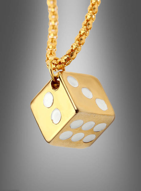 Ein goldener Würfelanhänger mit weißen Punkten hängt an einer strukturierten Goldkette vor einem grauen Farbverlaufshintergrund und verkörpert den Charme der „Casino-Kette mit Würfel in Silber oder Gold“ – ein ideales Stück Glücksbringer-Schmuck.