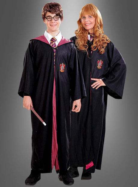 Zwei Personen, gekleidet im „Harry Potter-Kostüm Deluxe für Erwachsene“ – komplett mit schwarzen Hogwarts-Roben, Gryffindor-Krawatten und einem Zauberstab – stehen Seite an Seite vor einem schlichten grauen Hintergrund – perfekt für deine nächste Harry-Potter-Mottoparty.