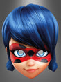 Eine 3D-animierte Figur, die von der „Ladybug-Maske aus Miraculous“ inspiriert ist, mit blauen Haaren und einer roten Maske mit schwarzen Punkten, blickt mit einem leichten Lächeln vor sich hin vor einem grauen Hintergrund.