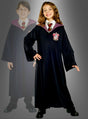 Ein Mädchen im Vordergrund und die schemenhafte Gestalt eines Jungen im Hintergrund tragen beide identische Hermine-Granger-Gryffindor-Roben, bestehend aus schwarzen Roben, gestreiften Krawatten und gestickten Hauswappen, die von den klassischen Harry-Potter-Kostümen inspiriert sind.