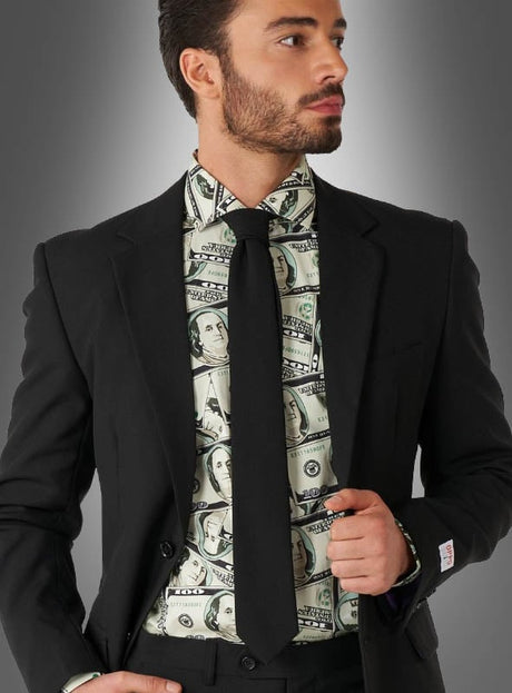 Ein Mann in schwarzem Anzug und schwarzer Krawatte trägt ein „Geldschein Hemd Cashanova OppoSuits“-Hemd mit einem Aufdruck in Form eines US-Dollar-Scheins und steht vor einem grauen Hintergrund mit Farbverlauf.