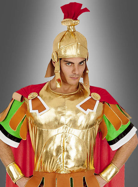 Vor einem grauen Hintergrund mit Farbverlauf steht eine Person im Asterix-Römerkostüm „Centurio“, das aus einem glänzenden goldenen Kostüm mit rotem Umhang, einem goldenen Helm und bunten Schulterverzierungen besteht.