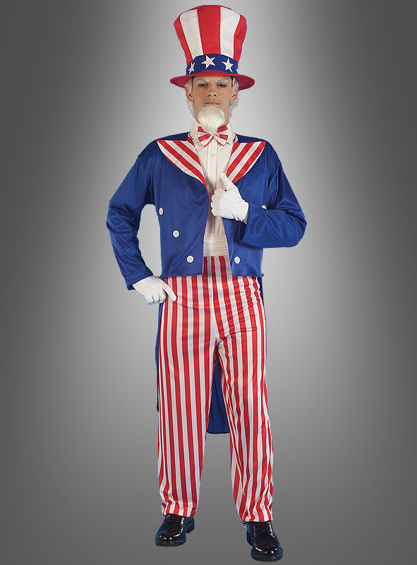 Eine Person im „Onkel Sam“-Kostüm, der US-amerikanischen Nationalfigur, bestehend aus einem blauen Mantel, rot-weiß gestreiften Hosen, einer Fliege und einem Zylinder, steht vor einem grauen Hintergrund.