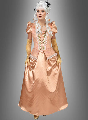 Eine Person trägt das „Edles Barock Kleid lang Apricot rose“ mit Spitzenbesatz, gelbe Handschuhe, eine weiße Lockenperücke und eine Perlenkette und steht vor einem grauen Hintergrund.