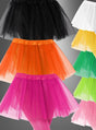 Tütü Kinder-Tüllröcke mit fünf Lagen Tüll in den Farben Schwarz, Weiß, Orange, Gelb, Grün und Rosa werden vor einem grauen Hintergrund mit Farbverlauf präsentiert.