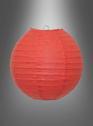 Ein runder roter „Papierlampion in kräftigen Farben (20–45 cm)“ mit einem stabilen Metallrahmen ist vor einem grauen Hintergrund mit Farbverlauf aufgehängt und eignet sich somit ideal als Partydekoration für Ihre nächste Gartenparty.
