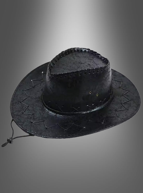 Ein Cowboyhut für Damen und Herren (unisex) aus schwarzem Leder mit Ziernähten und Kinnriemen, die perfekte Ergänzung für jedes Cowboy-Kostüm, präsentiert vor einem grauen Hintergrund mit Farbverlauf.