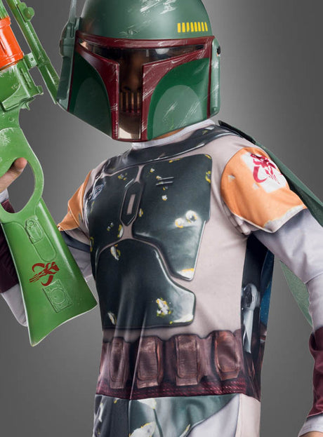 Ein Kind im Boba-Fett-Kinderkostüm mit fotorealistischem Aufdruck, das einen grünen Helm trägt und einen großen grünen Spielzeugblaster vor einem grauen Hintergrund in der Hand hält, präsentiert die authentische mandalorianische Rüstung, die von den Kostümdesigns aus „Star Wars“ für Kinder inspiriert ist.