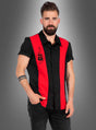 Ein bärtiger Mann, der ein schwarzes, kurzärmeliges „Rockabilly Hemd Dean“-Shirt mit roten vertikalen Streifen und einem Gitarrenmotiv trägt, steht vor einem grauen Hintergrund mit Farbverlauf.