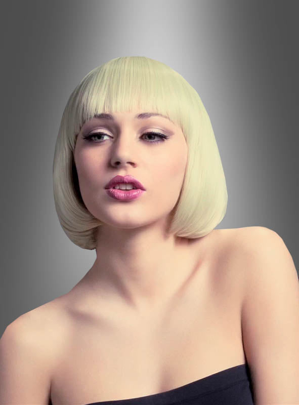 Eine Frau, die die Bobfrisur-Perücke „Mia“ trägt – eine elegante, platinblonde Perücke mit Pony –, posiert in einem trägerlosen schwarzen Oberteil vor einem grau verlaufenden Hintergrund. Damit ist sie die ideale hitzebeständige Perücke, um den Glamour einer 20er-Jahre-Party zu verkörpern.