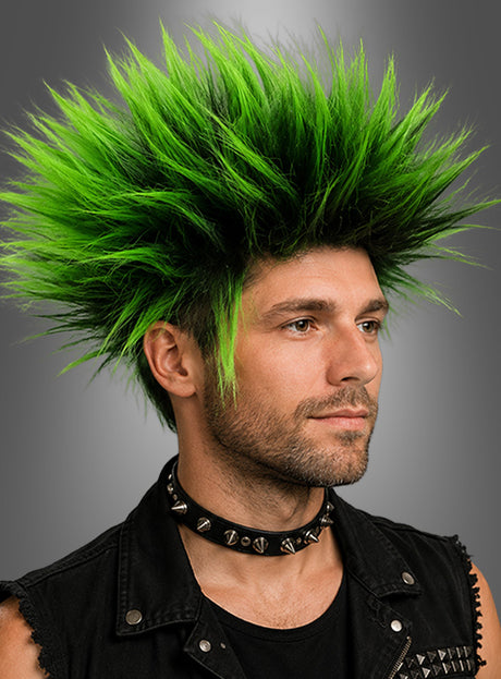 Eine Person, die ein schwarzes Choker-Halsband mit Nieten und eine ärmellose Weste trug und deren hellgrünes, zu Spitzen gestyltes Haar mit der 80er-Punk-Perücke in Rot oder Grün ergänzt wurde, posierte vor einem grauen Hintergrund.