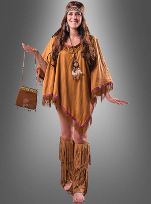 Vor einem grauen Hintergrund mit Farbverlauf steht eine Frau barfuß und trägt das braune „Wandelbarer Poncho mit Fransen“-Hippie-Indianer-Kostüm mit Fransen, ergänzt durch ein Stirnband und eine dazu passende Tasche.