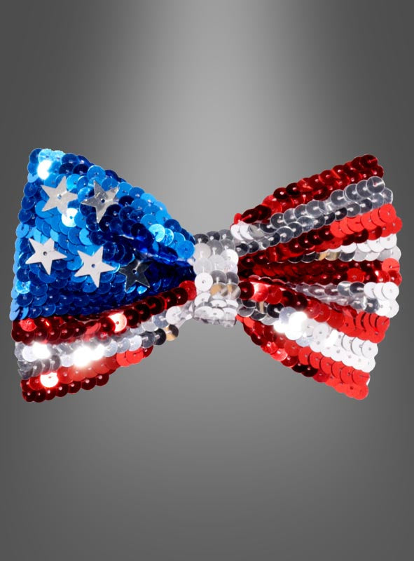 Wir präsentieren die USA-Paillettenfliege: eine funkelnde Fliege mit Pailletten, inspiriert von der amerikanischen Flagge, mit blauen und weißen Sternen auf der einen Seite und leuchtend roten, weißen und silbernen Streifen auf der anderen. Vor einem grauen Hintergrund mit Farbverlauf ist diese auffällige USA-Paillettenfliege das perfekte Amerika-Party-Accessoire für patriotische Feierlichkeiten oder Themenveranstaltungen – eine echte Paillettenfliege, die jedem Outfit einen umwerfenden Touch verleiht.