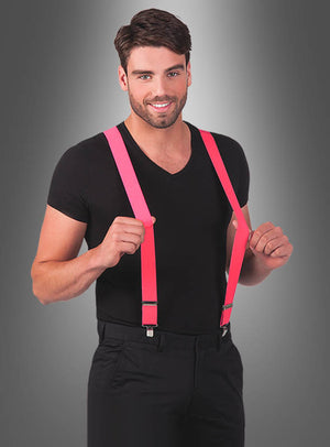 Ein Mann in schwarzem T-Shirt und Hose, der lächelnd „Stylische Neon-Hosenträger in tollen Farben“ vor einem grauen Farbverlaufshintergrund in die Kamera hält – perfekt, um jeder 80er- und 90er-Jahre-Party eine verspielte Note zu verleihen.