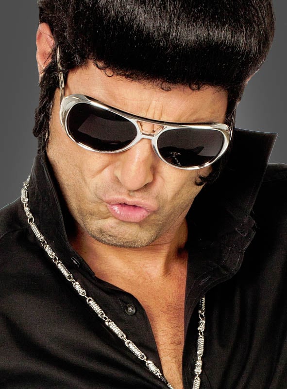 Ein Mann mit einer Pompadour-Frisur, der die große silberne Sonnenbrille „King of Rock Elvis Brille 60er“, ein schwarzes Hemd und eine Halskette trägt und dabei ein „Duckface“ macht.