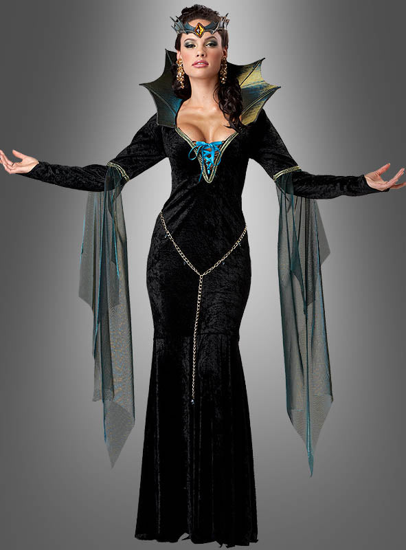 Eine Frau, die das „Figurbetontes Kleid böse Zauberin“ trägt – ein schwarzes, bodenlanges Fantasiekleid mit transparenten, flügelartigen Ärmeln, goldenen Ketten und einem passenden Kopfschmuck –, steht mit erhobenen Armen vor einem grauen Hintergrund mit Farbverlauf.