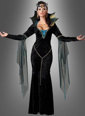 Eine Frau, die das „Figurbetontes Kleid böse Zauberin“ trägt – ein schwarzes, bodenlanges Fantasiekleid mit transparenten, flügelartigen Ärmeln, goldenen Ketten und einem passenden Kopfschmuck –, steht mit erhobenen Armen vor einem grauen Hintergrund mit Farbverlauf.