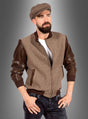 Ein bärtiger Mann trägt eine braune Schirmmütze, die Vintage-Herrenjacke „Duke Rockabilly“ in Braun und Beige, ein weißes T-Shirt und Jeans und steht mit den Händen in den Taschen vor einem grauen Hintergrund mit Farbverlauf.