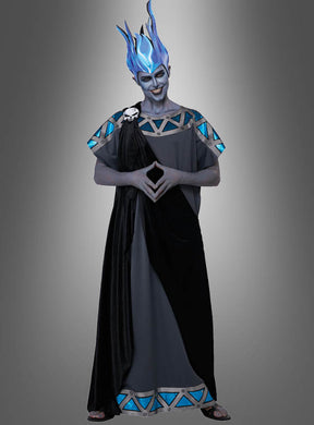 Eine Person mit einer Perücke in Form einer blauen Flamme und einer grauen Toga mit blauen Akzenten, deren Gesicht grau bemalt ist, steht mit gefalteten Händen vor einem grauen Hintergrund mit Farbverlauf – ideal für alle, die nach dem „Herrscher der Unterwelt“-Kostüm für Herren suchen.