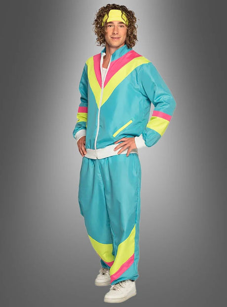 Eine Person, die den „80er Trainingsanzug blau“ trägt – einen Retro-Trainingsanzug im Stil der 80er Jahre in Blau, Gelb und Rosa – mit einem passenden Stirnband und weißen Sneakers, vor einem grauen Hintergrund mit Farbverlauf.
